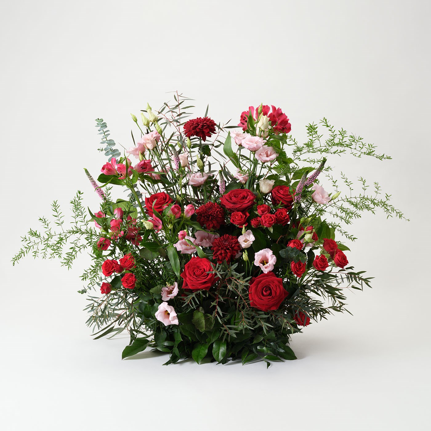 High funeral arrangement in red and pink